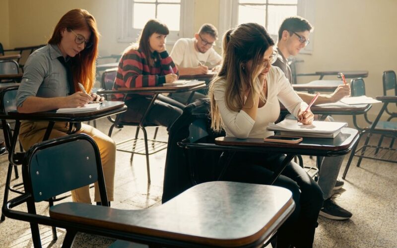 Student pracujący nad laptopem nad magisterską pracą z zarządzania
